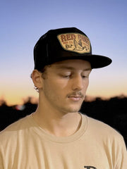 Red Dirt RDHC-488 FLY SOUTH Trucker Cap Black on model. If you need any assistance with this item or the purchase of this item please call us at five six one seven four eight eight eight zero one Monday through Saturday 10:00a.m EST to 8:00 p.m EST