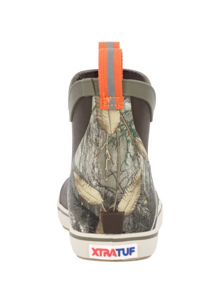 A single Xtrafut ankle boot shown from the back, featuring a woodland camouflage pattern on the upper, a dark brown heel, and an orange pull tab with a gray reflective stripe. If you need any assistance with this item or the purchase of this item please call us at five six one seven four eight eight eight zero one Monday through Saturday 10:00a.m EST to 8:00 p.m EST