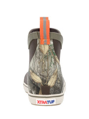 A single Xtrafut ankle boot shown from the back, featuring a woodland camouflage pattern on the upper, a dark brown heel, and an orange pull tab with a gray reflective stripe. If you need any assistance with this item or the purchase of this item please call us at five six one seven four eight eight eight zero one Monday through Saturday 10:00a.m EST to 8:00 p.m EST