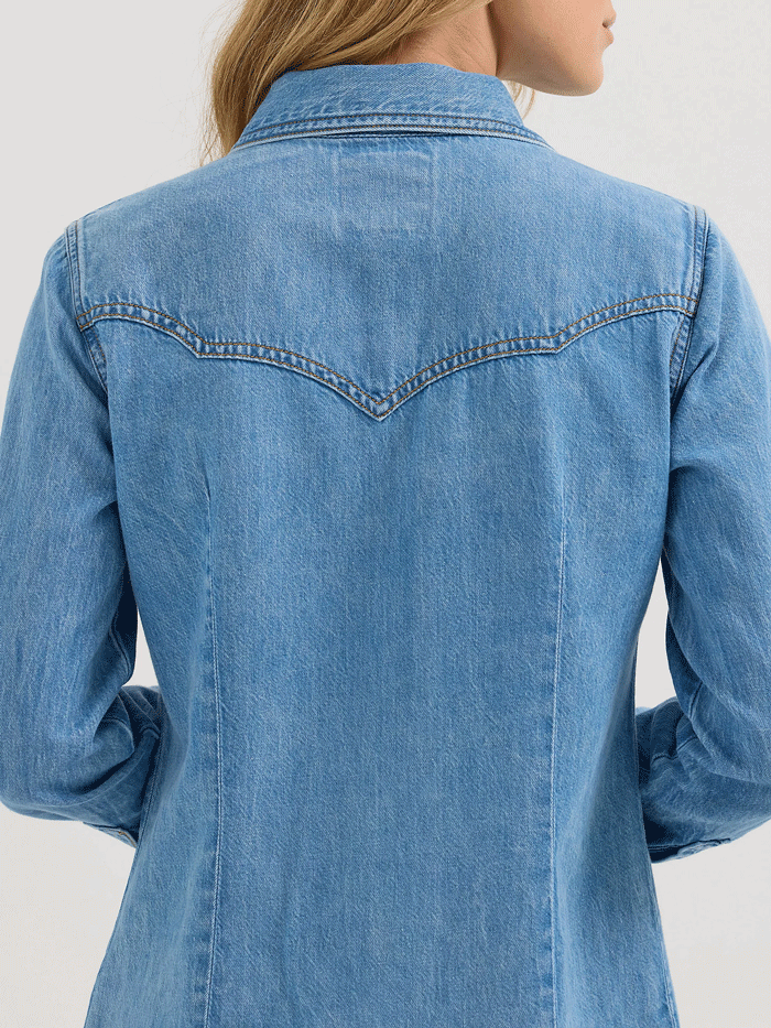 Wrangler 112360616 Womens X Lainey Wilson Moxie Western Denim Shirt Mid Wash Light Blue front view. If you need any assistance with this item or the purchase of this item please call us at five six one seven four eight eight eight zero one Monday through Saturday 10:00a.m EST to 8:00 p.m EST

