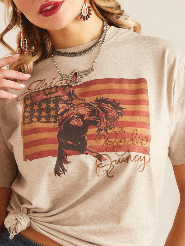 Ariat 10048669 Womens Flag Rodeo Quincy T-Shirt Gold Tan front view. If you need any assistance with this item or the purchase of this item please call us at five six one seven four eight eight eight zero one Monday through Saturday 10:00a.m EST to 8:00 p.m EST