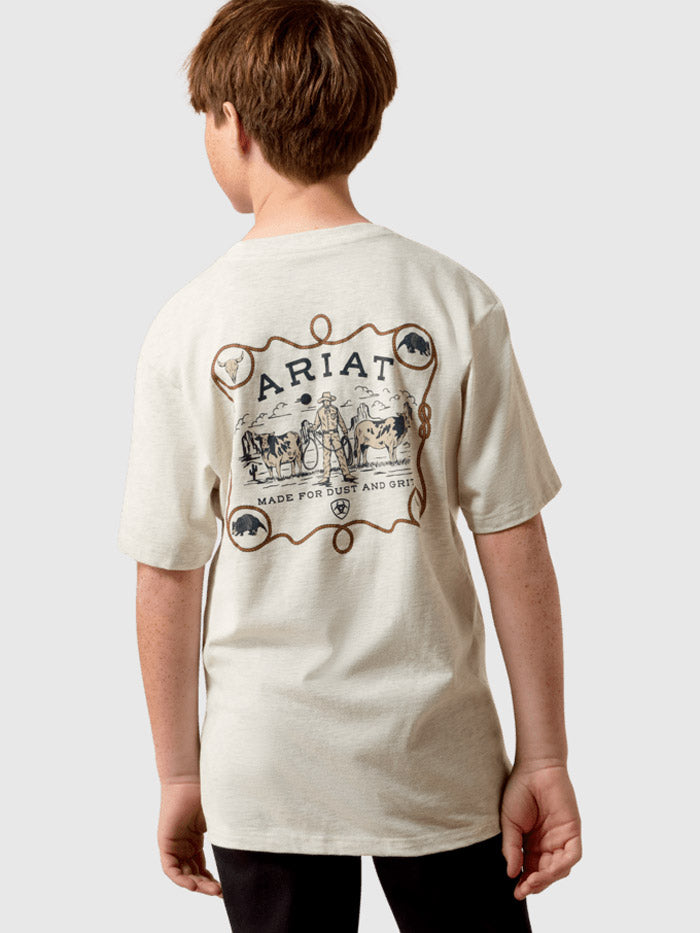 A child model shown from the back wearing a cream-colored t-shirt with a large brown graphic print on the back featuring the brand name 'Ariat' and western-themed illustrations. If you need any assistance with this item or the purchase of this item please call us at five six one seven four eight eight eight zero one Monday through Saturday 10:00a.m EST to 8:00 p.m EST