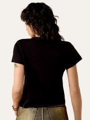 A person shown from the back wearing a plain black short-sleeve T-shirt and metallic gold pants against a light off-white studio background. If you need any assistance with this item or the purchase of this item please call us at five six one seven four eight eight eight zero one Monday through Saturday 10:00a.m EST to 8:00 p.m EST