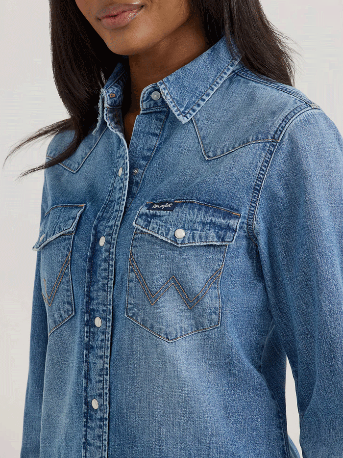 Wrangler 112360739 Womens Classic Denim Slim Western Snap Shirt Mid Wash front view. If you need any assistance with this item or the purchase of this item please call us at five six one seven four eight eight eight zero one Monday through Saturday 10:00a.m EST to 8:00 p.m EST