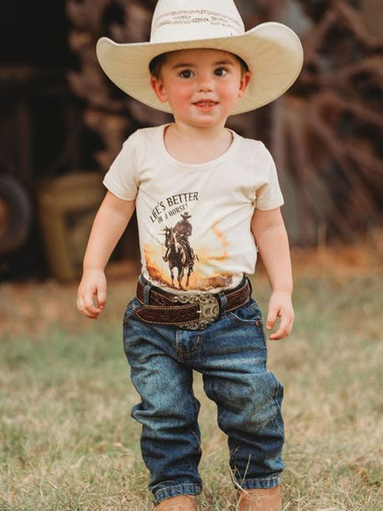 Shea Baby BVINB08 Kids Lifes Better On A Horse Onesie Beige front view on model. If you need any assistance with this item or the purchase of this item please call us at five six one seven four eight eight eight zero one Monday through Saturday 10:00a.m EST to 8:00 p.m EST