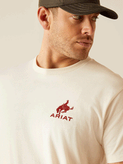 Ariat 10047898 Mens Bronco Flag T-Shirt Off White close up of front. If you need any assistance with this item or the purchase of this item please call us at five six one seven four eight eight eight zero one Monday through Saturday 10:00a.m EST to 8:00 p.m EST