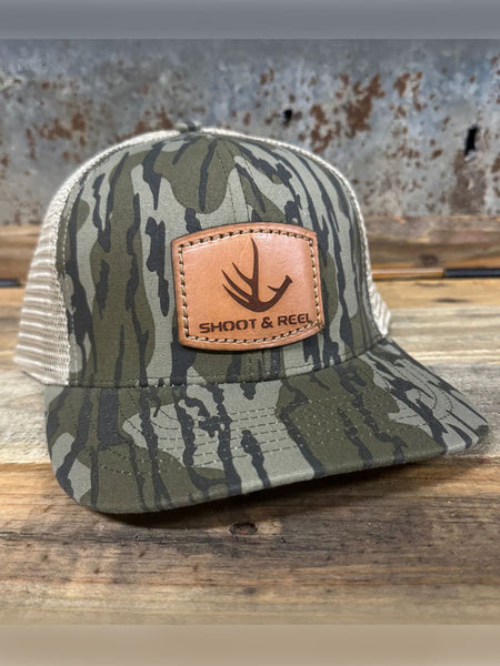 Shoot & Reel SR9 Antler Patch Curved Bill Cap Mossy Oak Bottomland side / front view. If you need any assistance with this item or the purchase of this item please call us at five six one seven four eight eight eight zero one Monday through Saturday 10:00a.m EST to 8:00 p.m EST