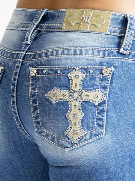 Miss Me M9358BV Womens Cross Mid Rise Boot Jean Medium Blue close up. If you need any assistance with this item or the purchase of this item please call us at five six one seven four eight eight eight zero one Monday through Saturday 10:00a.m EST to 8:00 p.m EST