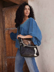 Myra Bag S-7956 Womens Spirit of the Herd HandTooled Bag Black on model. If you need any assistance with this item or the purchase of this item please call us at five six one seven four eight eight eight zero one Monday through Saturday 10:00a.m EST to 8:00 p.m EST