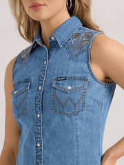 Wrangler 112361174 Womens Embellished Denim Sleeveless Snap Shirt Mid Wash front close up. If you need any assistance with this item or the purchase of this item please call us at five six one seven four eight eight eight zero one Monday through Saturday 10:00a.m EST to 8:00 p.m EST