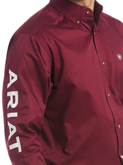 Ariat 10027995 Mens Team Logo Twill Classic Fit Shirt Burgundy sleeve close up. If you need any assistance with this item or the purchase of this item please call us at five six one seven four eight eight eight zero one Monday through Saturday 10:00a.m EST to 8:00 p.m EST