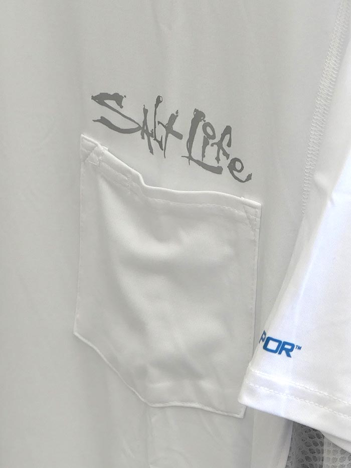 Salt Life SLM6082 Mens Fusion Performance SS Pocket Fishing Tee White a man wearing a shirt. If you need any assistance with this item or the purchase of this item please call us at five six one seven four eight eight eight zero one Monday through Saturday 10:00a.m EST to 8:00 p.m EST