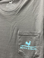 Beach and Barn TRACTOR-GRA Mens Tractor Pool LS Pocket Tee Graphite pocket close up. If you need any assistance with this item or the purchase of this item please call us at five six one seven four eight eight eight zero one Monday through Saturday 10:00a.m EST to 8:00 p.m EST