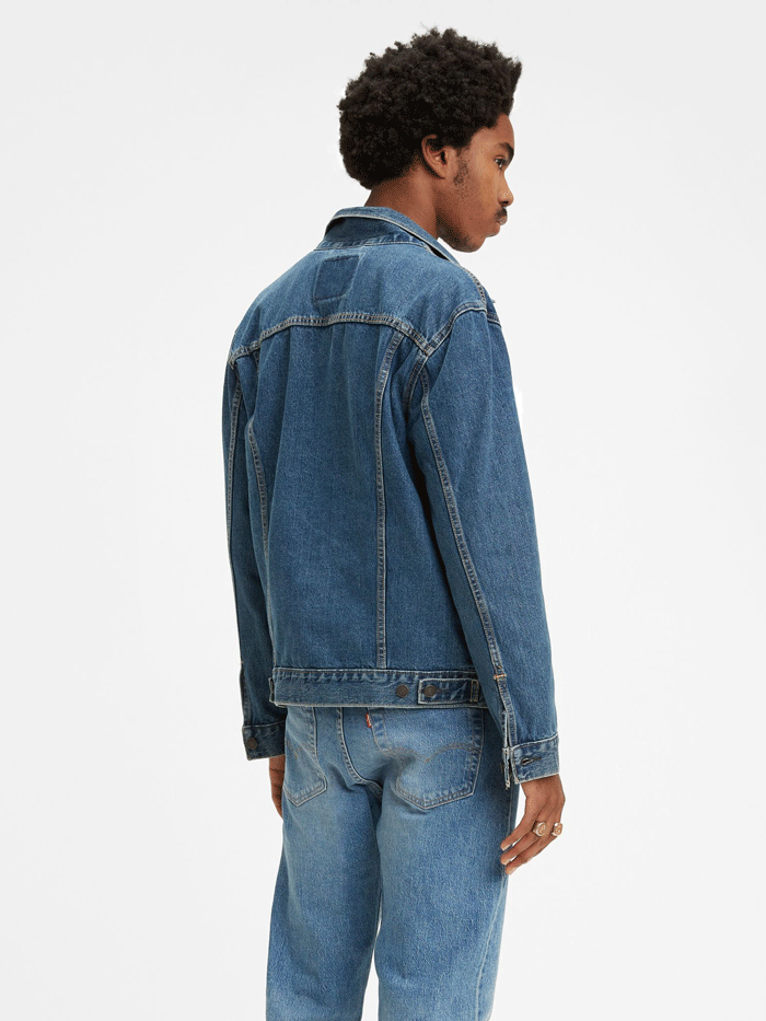 Levis 723340130 Mens Denim Trucker Jacket Medium Wash front view on model. If you need any assistance with this item or the purchase of this item please call us at five six one seven four eight eight eight zero one Monday through Saturday 10:00a.m EST to 8:00 p.m EST