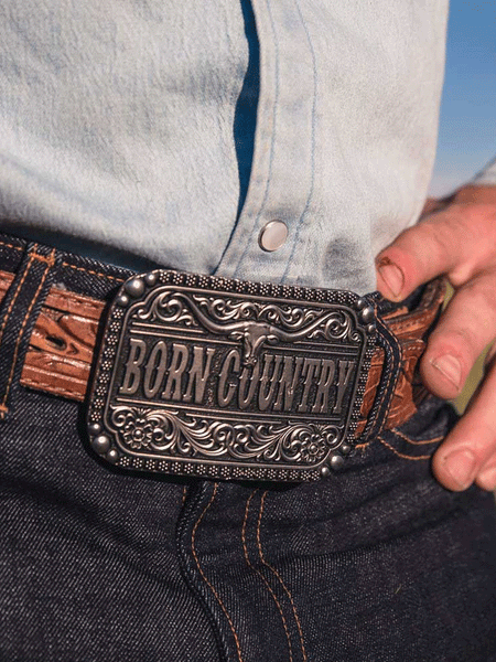 Montana Silversmiths A907 Born Country Attitude Buckle Silver on model. If you need any assistance with this item or the purchase of this item please call us at five six one seven four eight eight eight zero one Monday through Saturday 10:00a.m EST to 8:00 p.m EST