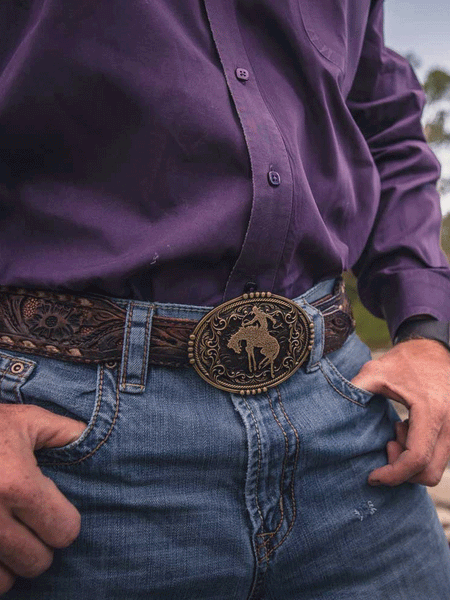 Montana Silversmiths A950 Bucking Bronc Attitude Buckle Bronze on model. If you need any assistance with this item or the purchase of this item please call us at five six one seven four eight eight eight zero one Monday through Saturday 10:00a.m EST to 8:00 p.m EST